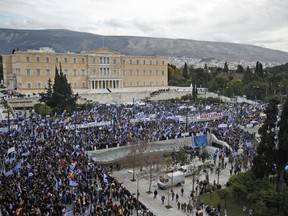 Protestors wave Greek flags outside parliament in Athens, Sunday, Jan. 20, 2019. Greece's Parliament is to vote this coming week on whether to ratify the agreement that will rename its northern neighbor North Macedonia. Macedonia has already ratified the deal, which, polls show, is opposed by a majority of Greeks.
