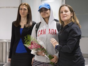 Saudi teenager Rahaf Mohammed Alqunun, centre, stands with Canadian Minister of Foreign Affairs Chrystia Freeland, right, as she arrives at Toronto Pearson International Airport.