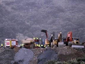 In this photo taken on Sunday, Jan. 20, 2019, drill and excavating machinery work on top of the mountain to reach a two-year-old boy trapped near the town of Totalan in Malaga, Spain.