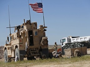 In this April 4, 2018 file photo, a U.S. soldier stands in a newly installed position near the front line between the U.S-backed Syrian Manbij Military Council and the Turkish-backed fighters, in Manbij, north Syria.