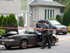 Police examine a car in front of home of Montreal businessman Tony Magi, on July 3, 2013. A manhunt was sparked after a man was spotted with an automatic weapon.