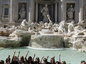 In this June 7, 2017, file photo, tourists throw their coins in the Trevi Fountain in Rome. The fountain is featured in several movies.