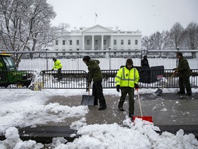National Park Service workers shovel snow outside of the White House, on January 13, 2019 in Washington, DC. The DC area was hit with 4-7 inches of snow accumulation with the potential of another 2-4 inches. President Donald Trump is holding off from a threatened national emergency declaration to fund a border wall amidst the longest partial government shutdown in the nation's history.