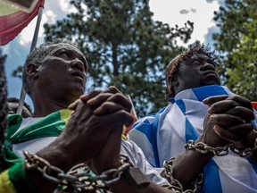 Members of the Africa Diaspora Forum (ADF), civil society organizations, churches, trade unions and other coalitions wore chains and shouted slogans during a demonstration against the slave trade and human trafficking in Libya on December 12, 2017 in Pretoria, South Africa.
