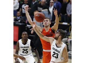 Colorado forward Lucas Siewert, front, battles for control of a rebound with Oregon State forward Tres Tinkle, center, as Colorado guard McKinley Wright IV looks on in the first half of an NCAA college basketball game Thursday, Jan. 31, 2019, in Boulder, Colo.