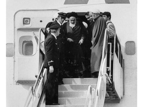 FILE - In this Feb. 1, 1979 file photo, Ayatollah Ruhollah Khomeini, Iran's exiled religious leader, emerges from a plane after his arrival at Mehrabad airport in Tehran, Iran. Friday, Feb. 1, 2019, marks the 40th anniversary of Khomeini's descent from the chartered Air France Boeing 747, a moment that changed the country's history for decades to come.
