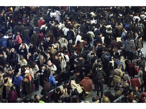 In this Jan. 28, 2019, photo, Chinese travelers wait for their trains at a railway station in Hangzhou in east China's Zhejiang province. The world's largest annual migration has began in China with millions of Chinese are traveling to their hometowns to celebrate the Lunar New Year on Feb. 5 this year which marks the Year of the Pig on the Chinese zodiac. (Chinatopix via AP)