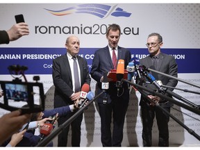 German Foreign Minister Heiko Maas, right, French Foreign Minister Jean-Yves Le Drian, left, and Jeremy Hunt United Kingdom's Secretary of State for Foreign and Commonwealth Affairs, stand during statements at a Gymnich meeting of EU foreign ministers in Bucharest, Romania, Thursday, Jan. 31, 2019.