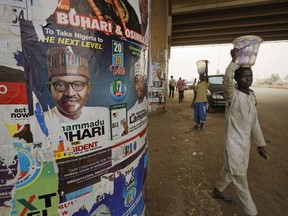 The face of incumbent President Muhammadu Buhari is seen on a campaign poster fixed to the pillars of a highway bridge near Nyanya, on the eastern outskirts of the capital Abuja, Nigeria Tuesday, Feb. 12, 2019. Nigeria is due to hold general elections on Saturday, Feb. 16, 2019.