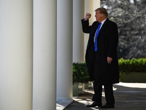 Donald Trump gestures as he walks back to the Oval office after speaking in the Rose Garden at the White House in Washington, DC on February 15, 2019.