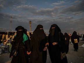 Veiled women walk together at al-Hol camp in al-Hasakeh governorate at northeastern Syria on February 17, 2019.