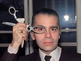 In this file photo taken in March 1987 German designer Karl Lagerfeld poses with scissors in his fashion studio.