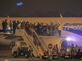 Bangladeshi security personnel stand guard near a Dubai-bound Bangladesh Biman plane on the tarmac of the Shah Amanat International Airport in Chittagong on Feb. 24, 2019.