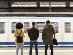 A group of people, donning different hair styles wait at a subway station. New York will pass legislation banning the discrimination of hair styles at work.
