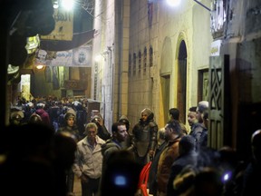 Policemen and residents surround the site of an explosion in the Gamaliya district, near Cairo's famed Khan el-Khalili tourist marketplace in Cairo, Egypt, late Monday, Feb. 18, 2019. Egypt's Interior Ministry says a suicide bomber killed a few police officers and wounded some more while he was being pursued near Cairo's famed Khan el-Khalili tourist marketplace.