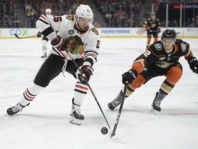 Chicago Blackhawks center Artem Anisimov, left, and Anaheim Ducks defenseman Brendan Guhle chase the puck during the first period of an NHL hockey game Wednesday, Feb. 27, 2019, in Anaheim, Calif.