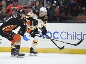 Boston Bruins center Joakim Nordstrom, right, passes the puck while under pressure from Anaheim Ducks defenseman Cam Fowler during the first period of an NHL hockey game Friday, Feb. 15, 2019, in Anaheim, Calif.