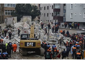 Rescue workers try to remove rubble from an eight-storey building which collapsed a day earlier in Istanbul, Thursday, Feb. 7, 2019. An eight-storey building collapsed in Istanbul Wednesday, and Istanbul Gov. Ali Yerlikaya told reporters early Thursday that rescue teams working overnight pulled 12 people out of the rubble with injuries and at least three people are confirmed dead.