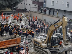 Rescue workers continue to remove rubble from an eight-story building which collapsed two days earlier in Istanbul, Friday, Feb. 8, 2019. Turkish rescue workers on Friday pulled out a 16-year-old boy from the rubble of an eight-story apartment building in Istanbul two days after it collapsed, Turkey's interior minister Suleyman Soylu said.
