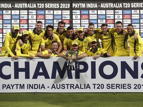 Members of Australian team pose with the winners trophy after their win in the second T20 international cricket match against India in Bangalore, India, Wednesday, Feb. 27, 2019.
