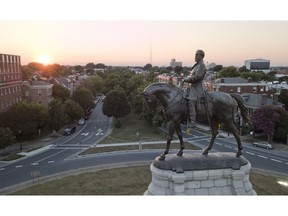 In this July 31, 2017 photo, the sun sets behind the statue of confederate General Robert E. Lee on Monument Avenue in Richmond, Va. Virginia has become more diverse and socially liberal in recent years. But the state continues to struggle with mindsets shaped by its turbulent racial history. When a racist photo was discovered last week on Gov. Ralph Northam's 1984 medical school yearbook page, it exposed how much deeply embedded racism still lurks in the state.