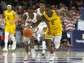 Arizona guard Justin Coleman and California guard Juhwan Harris-Dyson (2) races for the ball during the first half of an NCAA college basketball game Thursday, Feb. 21, 2019, in Tucson, Ariz.
