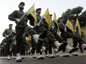 FILE - In this Nov. 12, 2010 file photo, Hezbollah fighters parade during the inauguration of a new cemetery for their fighters who died in fighting against Israel, in a southern suburb of Beirut, Lebanon. The British government will make inciting support for Hezbollah a criminal offense as senior officials accused the Iran-backed organization of destabilizing the Middle East.