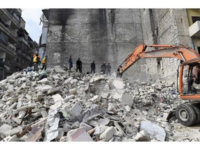 In this photo released by the Syrian official news agency SANA, people inspect a destroyed building where, according to SANA, the five-story building collapsed early Saturday, Feb. 2, 2019,  killing most of those who were inside and only one person was rescued alive, in the northern city of Aleppo, Syria. SANA said that a building damaged during years of war in the northern city of Aleppo has collapsed killing 11 people. (SANA via AP)