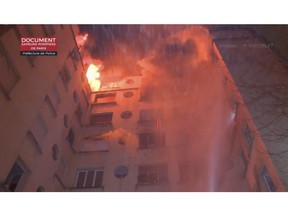 In this image taken from video released by the Paris Fire Dept., fire fills the top floors of an apartment building, Tuesday, Feb. 5, 2019, in Paris, France. A fire in a Paris apartment building has killed a number of people and sent residents fleeing to the roof or climbing out windows to escape. (Paris Fire Dept. via AP)