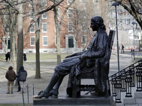 FILE - In this Dec. 13, 2018 file photo, the John Harvard statue looks over Harvard Yard at Harvard University in Cambridge, Mass. A final round of arguments is scheduled for Wednesday, Feb. 13, 2019, in federal court in Boston in a trial alleging racial bias in the university's admissions system.