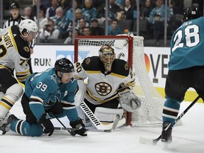 Boston Bruins goalie Tuukka Rask (40) and Charlie McAvoy, left, defend against San Jose Sharks' Logan Couture (39) and Timo Meier, right, during the first period of an NHL hockey game Monday, Feb. 18, 2019, in San Jose, Calif.