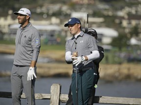 Jordan Spieth, right, follows his shot from the seventh tee of the Pebble Beach Golf Links as Dustin Johnson looks on during the third round of the AT&T Pebble Beach Pro-Am golf tournament Saturday, Feb. 9, 2019, in Pebble Beach, Calif.
