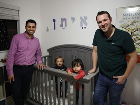 In the Tuesday, Jan. 23, 2018 file photo, Elad Dvash-Banks, left, and his partner, Andrew, pose for photos with their twin sons, Ethan, centre right, and Aiden in their apartment in Los Angeles.