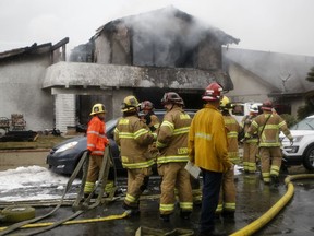 FILE - In this Sunday, Feb. 3, 2019 file photo, firefighters suppress a fire at the scene of a deadly plane crash in the residential neighborhood of Yorba Linda, Calif. The Federal Aviation Administration said a twin-engine Cessna 414A crashed in Yorba Linda shortly after taking off from the Fullerton Municipal Airport. The pilot whose plane broke apart and crashed into the Southern California home, killing five people, was disciplined for dangerous flying years earlier, it was reported Friday, Feb. 8.