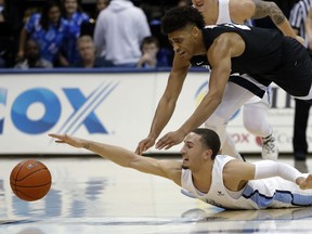 San Diego guard Tyler Williams, below, reaches for a loose ball as Gonzaga forward Jeremy Jones defends during the first half of an NCAA college basketball game Saturday, Feb. 16, 2019, in San Diego.