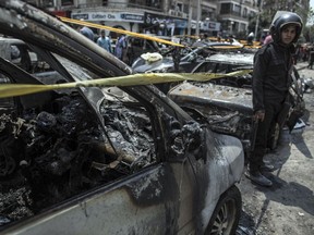 FILE - In this June 29, 2015 file photo, a policeman stands guard at the site of a car bombing that killed Egypt's top prosecutor, Hisham Barakat, in Cairo. On Wednesday, Feb. 20, 2019 Egypt executed nine suspected Muslim Brotherhood members convicted of involvement in the 2015 assassination of Barakat, security officials said. The nine were found guilty of taking part in the bombing that killed Barakat, the first assassination of a senior official in Egypt in a quarter century.