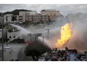 San Francisco firefighters battle a fire on Geary Boulevard in San Francisco, Wednesday, Feb. 6, 2019. The San Francisco Fire Department says several workers have been found safe after the gas explosion and fire and that no injuries have been reported.