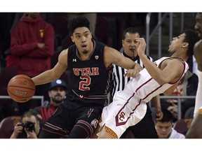 Utah guard Sedrick Barefield, left, knocks over Southern California guard Derryck Thornton on a drive during the first half of an NCAA college basketball game Wednesday, Feb. 6, 2019, in Los Angeles.