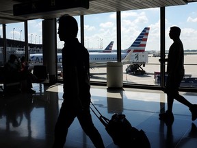 FILE - In this Aug. 1, 2016 file photo, passengers walk to their gates through the terminal as American Airlines planes wait to depart at O'Hare International Airport in Chicago. O'Hare International Airport was the busiest airport in the U.S. last year, surpassing Hartsfield-Jackson Atlanta International Airport for the first time in four years, according to data released Monday, Feb. 4, 2019, by the Federal Aviation Administration.