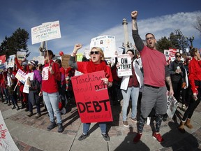 Rebecca Carlson, center, a teacher at Johnson Elementary School, joins fellow striking Denver Public Schools instructors during a rally in Civic Center Park, Tuesday, Feb. 12, 2019, in Denver. The strike, which is in its second day, is the first for Denver's teachers since 1994.