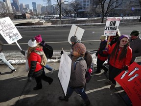 Teachers carry placards as they march along Speer Boulevard from West High School Monday, Feb. 11, 2019, in Denver. Denver teachers went on strike Monday after failing to reach a deal with administrators on pay in the latest example of educator discontent, following a wave of walkouts over the last year.