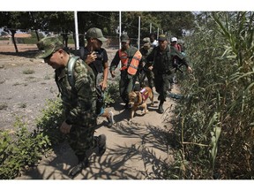 Colombian soldiers escort two Venezuelan National Guardsmen who deserted their post near the Simon Bolivar International Bridge, in La Parada, Colombia, Monday, Feb. 25, 2019.