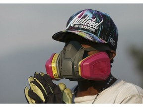 An anti-government Venezuelan migrant wearing protective gear rests from confrontations with Venezuelan National Guards who are blocking the Simon Bolivar International Bridge, in La Parada near Cucuta, Colombia, Sunday, Feb. 24, 2019, on the border with Venezuela. A U.S.-backed drive to deliver foreign aid to Venezuela on Saturday met strong resistance as troops loyal to President Nicolas Maduro blocked the convoys at the border and fired tear gas on protesters.