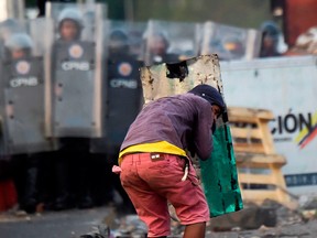 A supporter of Venezuelan opposition leader Juan Guaido confronts Venezuelan security forces during clashes on the Venezuelan side of the Francisco de Paula Santander International Bridge, as seen from Cucuta, Colombia, on Feb. 25, 2019.