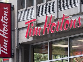 A Tim Hortons logo is pictured Tuesday, June 21, 2016 in Montreal. Restaurant Brands International Inc., the company behind Tim Hortons, Burger King and Popeyes restaurants, narrowly topped profit expectations as it reported its fourth-quarter results.