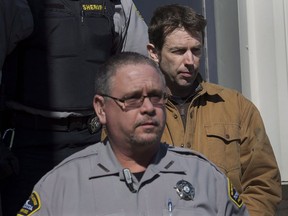 John Mark Tillmann, right, charged with possession of stolen property, is escorted by sheriffs from provincial court in Dartmouth on Wednesday, Feb. 27, 2013. A man who filled his suburban lakeside home with historic artifacts and art stolen over two decades of pilfering so stealthy that many of his targets didn't even know they'd been victimized, has died. John Mark Tillmann was 57. Tillman stole from universities, libraries, museums, antique dealers and private collections across Atlantic Canada.