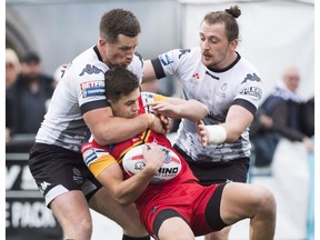 Toronto Wolfpack players Josh McCrone, left, and Andrew Dixon, right, tackle London Broncos forward Alex Walker, centre, during first half rugby league action in Toronto on Sunday, October 7, 2018. The Toronto Wolfpack have a new coach and a new marquee back among a half-dozen reinforcements. But the goal for the transatlantic rugby league team remains the same this year ??? earn promotion to the Super League.