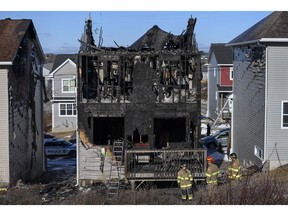 Firefighters investigate following a house fire in the Spryfield community in Halifax on Tuesday, February 19, 2019. Experts say the deaths of the seven Barho children in a ferocious Halifax house fire last week could lead to new fire safety measures and changes to the country's building code.