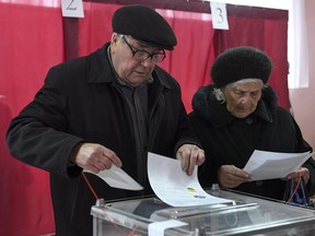 People cast their ballots at a polling station during rebel elections in Donetsk, Ukraine, Sunday, Nov. 11, 2018. The first waves of Canadian election monitors have arrived in Ukraine, as fears rise over Russian meddling in the March 31 presidential ballot. THE CANADIAN PRESS/ AP
