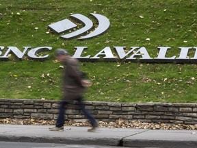 A man walks past the headquarters of SNC Lavalin in Montreal on November 6, 2014. For more than a century, SNC-Lavalin has been viewed with pride in Quebec as it grew from a small firm specializing in hydraulics into a global engineering and construction giant.Founded in 1911, it gained a reputation for building a large dam in Quebec that spearheaded the province's development of hydroelectricity and developing the skillsets for thousands of Quebec workers.